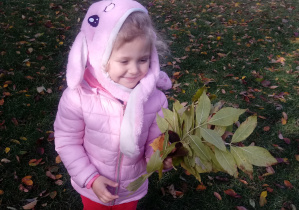 Dziewczynka trzyma bukiet z jesiennych liści